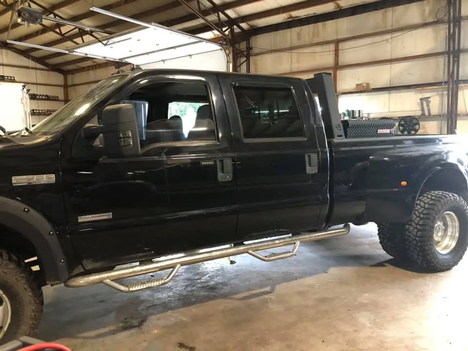 A black Ford Super Duty dually pickup parked inside the Battle Creek Diesel service bay